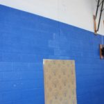 Oversized patch over damaged gym wall.